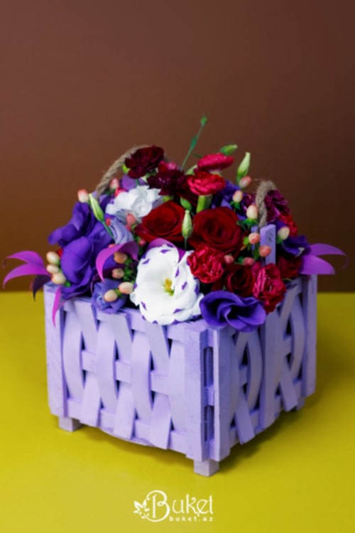 Composition in a wooden basket of roses and irises